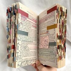 an open book with many different colored papers on it's pages and some writing