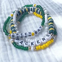 🏈 Who loves football? Who loves the Green Bay Packers? Show your team spirit with this fun bracelet set! Great for gift giving!! Lightweight and oh so comfy to wear. Available as a 3 or 4 piece set. The 4 piece set includes faceted crystals to make it super sparkly! It will also have gold accents to match the other bracelets. Each piece is handmade with: - High Quality Glass Seed Beads - Heishi Vinyl Beads - White/Black Acrylic Round and Cube Letter Beads - Faceted Rondelle Crystals (in 4 piece Cheap Beaded Stretch Bracelet For Sports Events, Team Spirit Bracelets With Letter Beads, Team Spirit Beaded Bracelets For Game Day, Game Day Team Spirit Stretch Bracelet With Round Beads, Game Day Bracelets With Letter And Round Beads, Team Spirit Round Beads Jewelry For Game Day, Team Spirit Letter Beads Wristband For Game Day, Team Spirit Wristband With Letter Beads For Game Day, Personalized Beaded Bracelets For Game Day