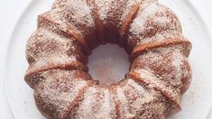 a bundt cake with powdered sugar on top sits on a white platter