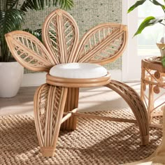 a chair made out of wicker with a white cushion