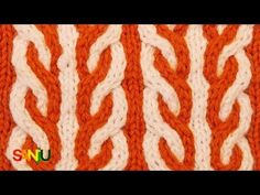 an orange and white knitted blanket with wavy lines on the bottom, in different colors