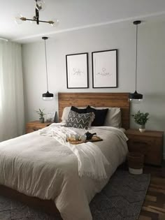 a bed sitting in a bedroom next to two framed pictures on the wall above it