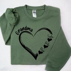 a green sweatshirt with the words grandma written on it and hearts drawn in black ink