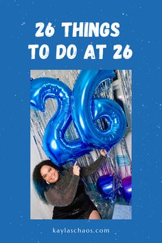 a woman holding blue balloons with the words 26 things to do at 26