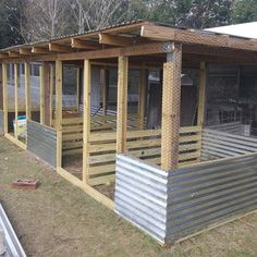 an outdoor chicken coop in the middle of a yard with metal and wood sidings