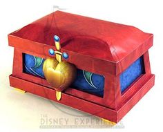 a red box with blue and yellow designs on the inside is open to reveal an object