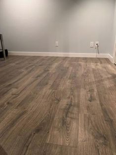 an empty room with hard wood flooring and white paint on the walls is seen in this image