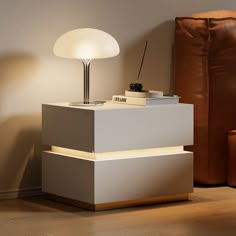 a lamp sitting on top of a white table next to a brown chair and ottoman