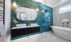 a bathroom with green tile and white fixtures