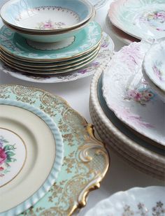 a table topped with lots of plates covered in different colors and designs on top of each other