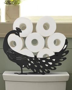 a toilet with rolls of toilet paper in the shape of a peacock sitting on top of it