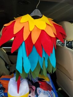 a stuffed bird sitting on top of a car seat in the back of a vehicle