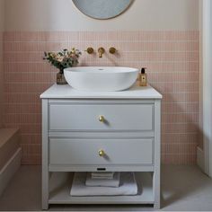 a white sink sitting under a mirror next to a wall mounted faucet in a bathroom