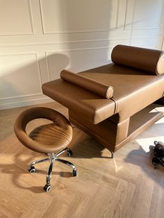 a chair and ottoman sitting on top of a hard wood floor next to a wall