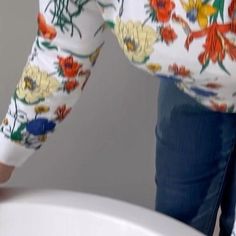 a woman is holding onto the edge of a toilet