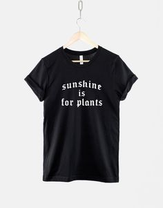 "The perfect Summer t-shirt for any gothic queen. This black top boldly states 'Sunshine Is For Plants' in white gothic text. A fine wardrobe addition for any goth girl who likes to keep themselves out of the sun, and into the shadows. Make sure you don't miss out on this gothy masterpiece by adding it to your cart! ALSO AVAILABLE AS A TANK TOP: https://www.etsy.com/uk/listing/1259182399/goth-summer-tank-top-black-goth-womens 📦 1-2 Day Dispatch Time  🚚 FREE & FAST Delivery 👇🏼 Sizing & Shippi Cheap Edgy Black T-shirt, Goth Summer Fashion, Gothic Text, Gothic Queen, Summer Goth, Black Goth, Funny Dad Shirts, Workout Sweatshirt, Fashion Black