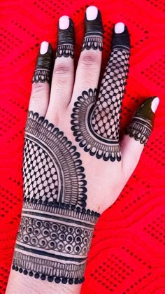 a woman's hand with henna tattoos on it