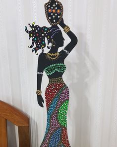 a paper cut out of a woman in a colorful dress holding a basket on her head