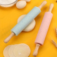 the ingredients for making bread are laid out on a yellow surface, including dough and rolling pin