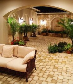 a living room filled with lots of furniture next to a brick floored patio area