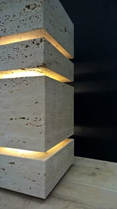 three stacked concrete blocks with lights on each side and the top lit up in yellow