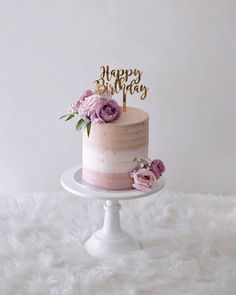 a birthday cake with pink frosting and flowers on top