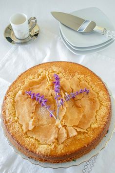 a cake sitting on top of a table next to a cup and saucer with a knife