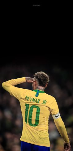 a soccer player saluting to the crowd with his hand on his head while standing in front of an audience