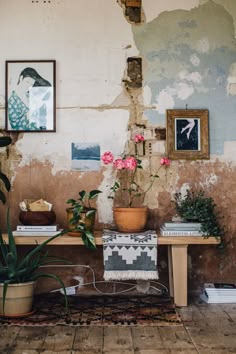 a table with flowers on it in front of a wall that has been torn down