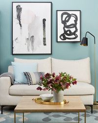 a living room filled with furniture and pictures on the wall above it's coffee table