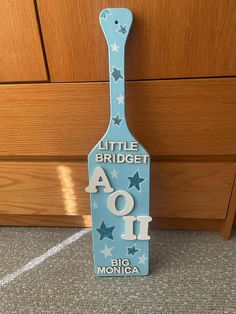 a blue wooden sign that says little bridgeet aoi with stars on the front