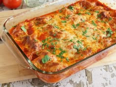 a casserole dish with meat, cheese and parsley in it on a cutting board