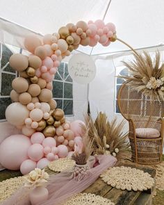 a table topped with lots of balloons next to a chair and other items on top of it