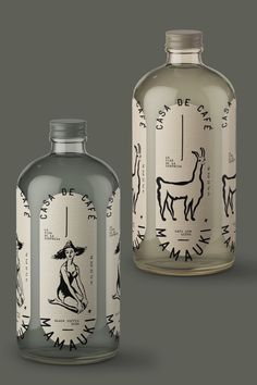 two bottles with designs on them sitting next to each other in front of a gray background