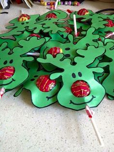 green paper cutouts with candy sticks sticking out of them