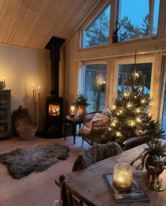 a living room filled with furniture and a fire place next to a window covered in christmas lights