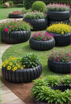 tires are used as planters for flowers and other plants in the garden, along with grass