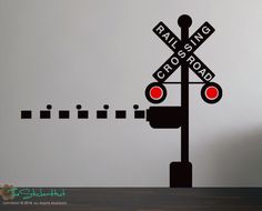 a railroad crossing wall decal on the side of a table with a lamp post