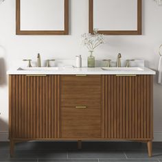 a bathroom with two sinks and mirrors on the wall