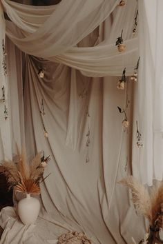 a bed with white curtains and flowers on it