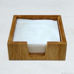 a wooden box with two napkins in it on a white tablecloth covered surface