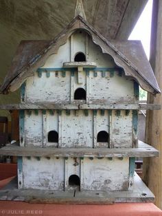 an old bird house is sitting on the floor