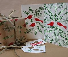 two christmas cards with red birds on them, tied up and wrapped in twine