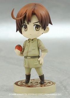 an anime figurine is posed on top of a base with a red apple in his hand