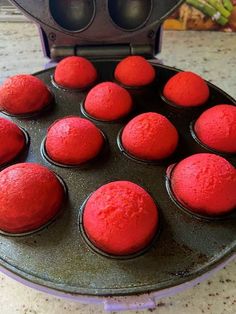 red cupcakes in a muffin pan ready to go into an electric oven