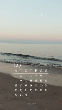 the july calendar is on the beach next to the ocean