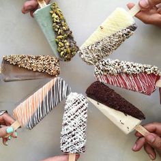 several people holding different types of ice cream on sticks