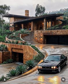 a black car parked in front of a house with steps leading up to the roof