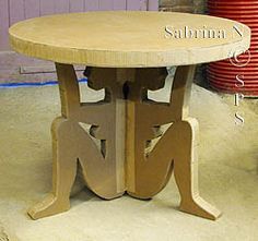 a table made out of cardboard sitting on top of a floor next to a red fire hydrant