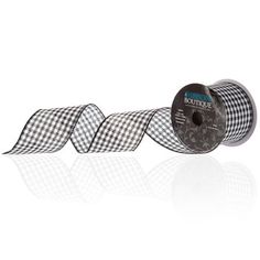 a roll of black and white checkered wired ribbon on a white background with reflection